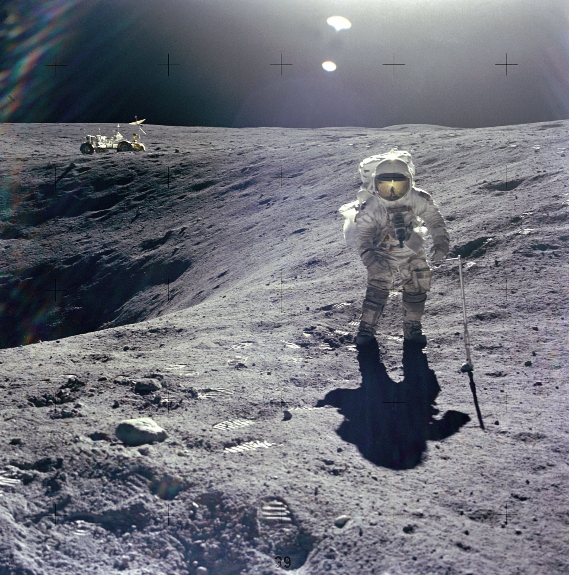 Astronaut Duke on the lunar surface at the edge of a crater