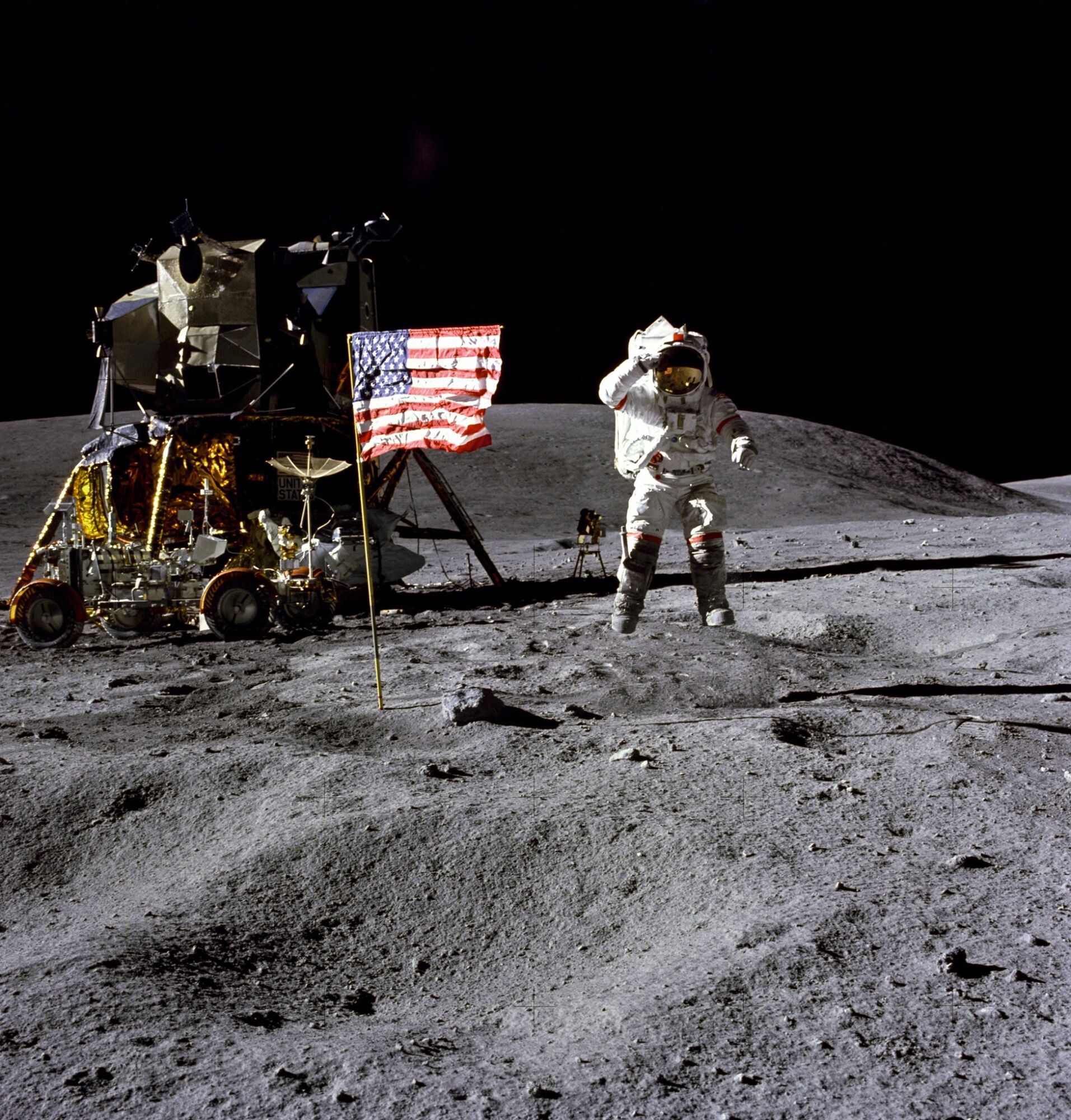 Astronaut Young saluting with flag in background during Apollo 16